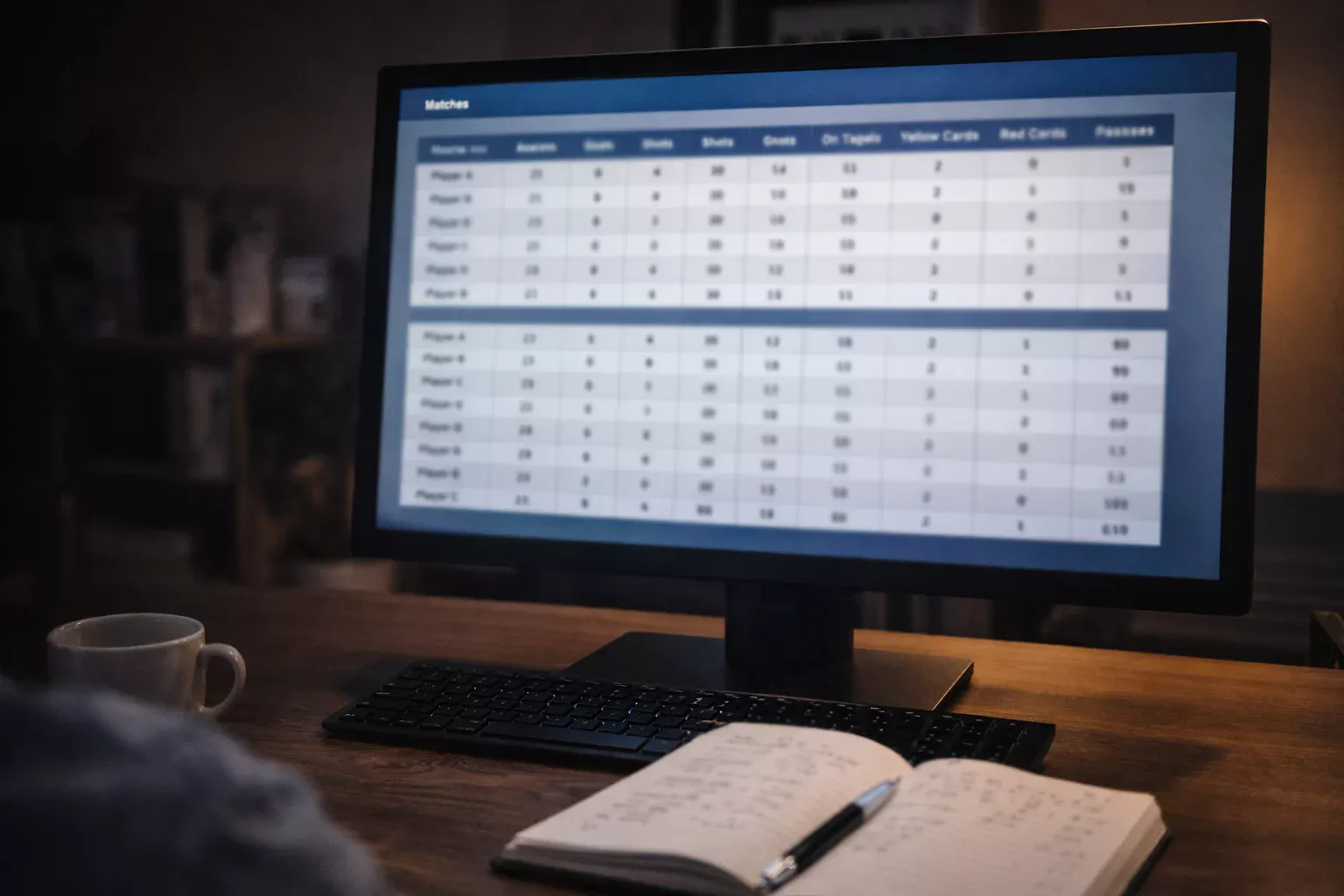 Écran d'ordinateur affichant des statistiques de football avec un carnet de notes ouvert à côté